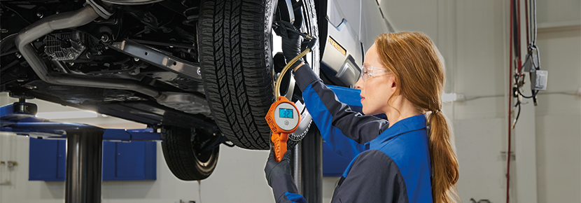 A Subaru technician checking tire pressure. | Romain Subaru in Evansville IN