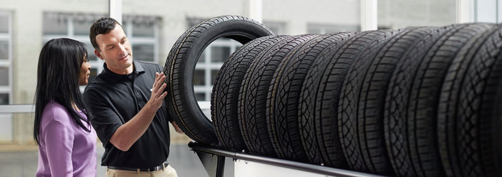 Subaru service representative showing customer a tire. | Romain Subaru in Evansville IN